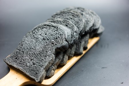 Organic bio charcoal bread on a wood tray.の写真素材