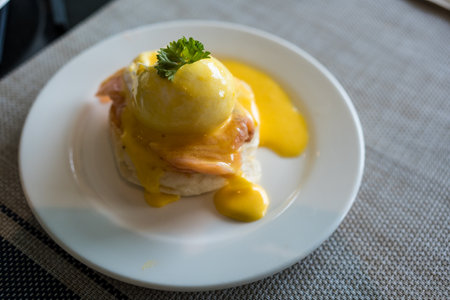 A delicious eggs benedict with salmon in white plate.の写真素材