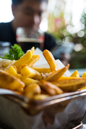Tasty french fries potatoes in metal basket. Close up