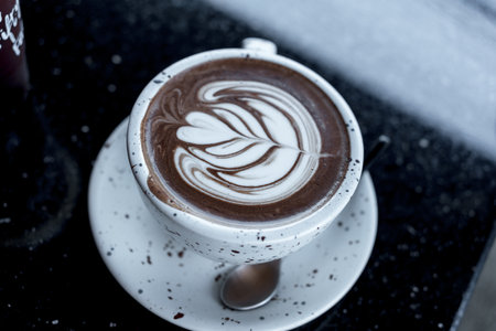 Close-up of hot chocolate art in white cup at cafeの写真素材