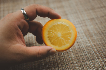 Closeup hand holding fresh slice lemon. Lemon (citrus fruits) contains a large amount of vitamins c