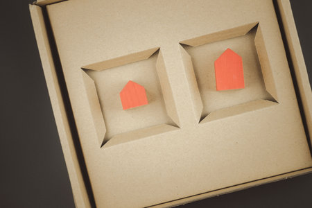 Two red miniature house in a brown box. Housing as a gift. Sale of real estate. Top viewの写真素材