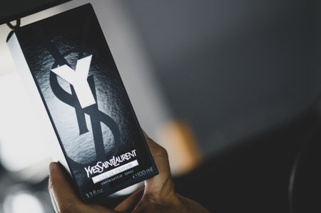 Samut Prakan, Thailand - July 29, 2023 : A box of Man perfumery Yves Saint Laurent Y EAU DE PARFUM in 100ml in man hand.のeditorial素材