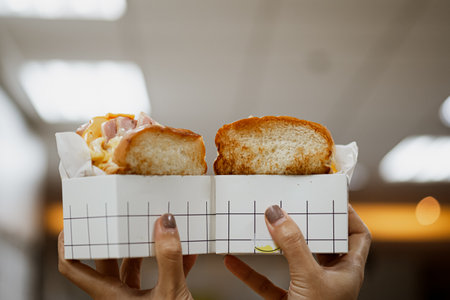 This Korean egg drop sandwich or scrambled egg sandwich. Egg drop sandwich is a popular Korean egg sandwich made with fluffy scrambled eggs, ham or bacon, and cheese.の写真素材