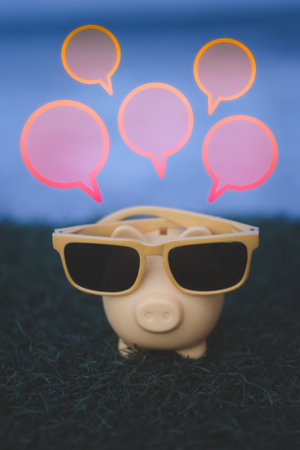 Yellow pig piggy bank wearing sunglasses with blank speech bubble. The concept of saving for travel