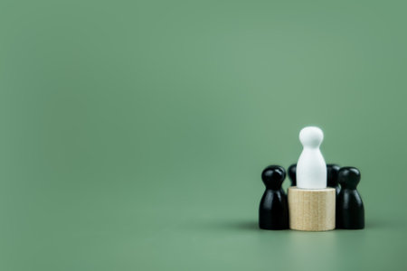 A white wood peg doll stand on podium and black wood peg doll on ground. Winner concept for business and competitionの写真素材