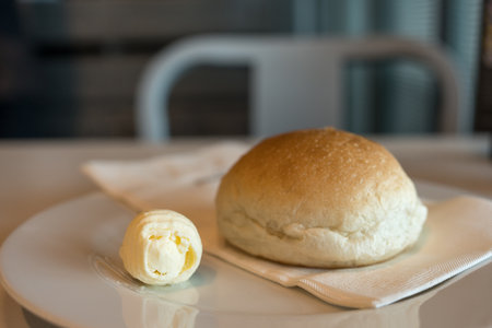 Fresh bread with fresh butter curls on the table in restaurant, closeupの写真素材