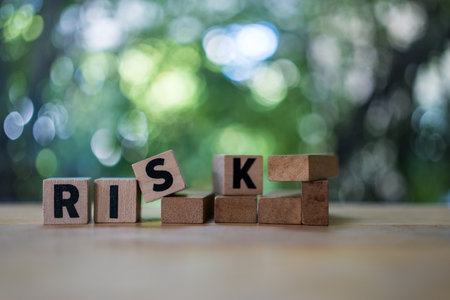 Four wood cubes with black letters spelling RISK. Risk Management and insurance concept, decision to accept business result in uncertaintyの写真素材