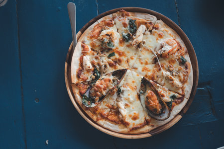 Delicious seafood pizza on wooden stand. Top viewの写真素材