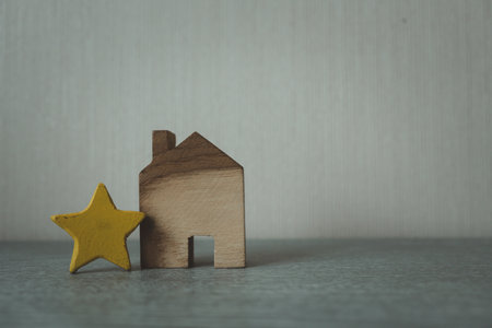 Wood home and yellow star shape with copy space. The concept of the best home