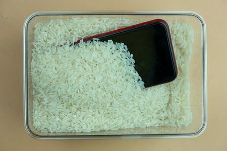Mobile phones is embedded with rice from falling on water. Top viewの写真素材