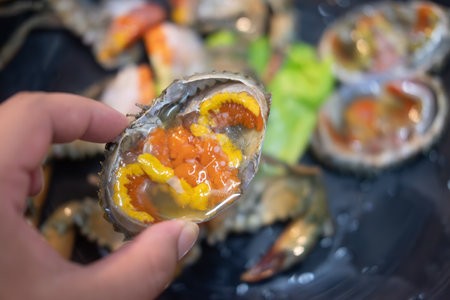 Pickled crab eggs in fish sauce in hand, exotic menu in Thailandの写真素材
