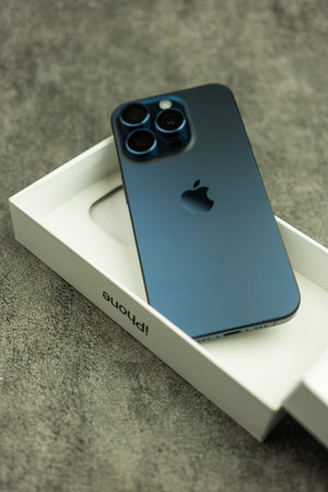 Bangkok, Thailand - October 23, 2023: Male hand latest iPhone 15 Pro Blue titanium features a triple-lens camera setup for professional-level mobile photography.のeditorial素材