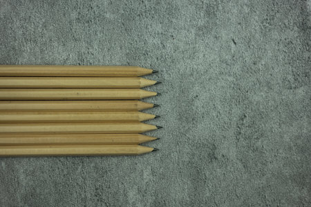 Many sharp pencils on a gray background. Education stationery tools concept. Minimalist style. Top...