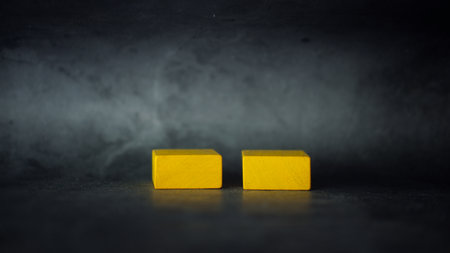Two yellow blocks on a black background, building blocksの写真素材