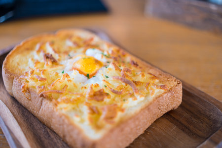 Egg in a hole and cheese toast serve on wooden board. Sandwiches for breakfast. The concept of delicious food, Selective focus.の写真素材