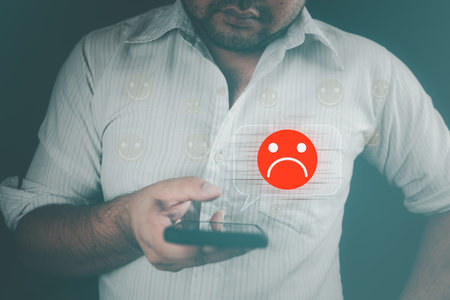 Unhappy man customer with choosing sad emotion face via smartphone. Bad review and service dislike poor quality, low rating, the order has been cancelled. Customer experience dissatisfied.の写真素材