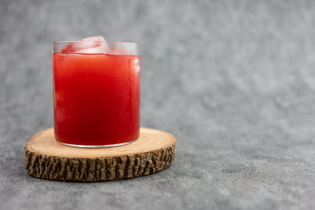 Fresh watermelon juice with ice on a wooden coaster. Homemade drinkの写真素材