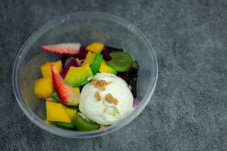 Yogurt with many fruits in a plastic cup to go. The fruit fruit such as strawberries, grapes, kiwi and mango put fresh yogurt.の写真素材