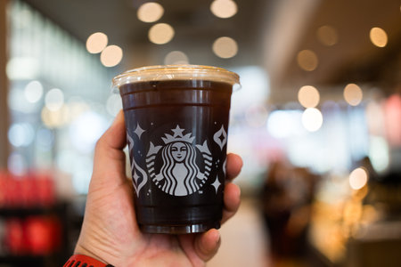 BANGKOK, THAILAND - November 30, 2023 : A cup of Starbuck iced Americano in hand at Starbuck shop. Close upのeditorial素材