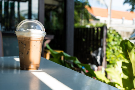 Refreshing iced Mocha coffee on table in a garden cafe on a beautiful summer day. Refreshing drink in a garden cafe.の写真素材