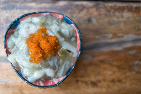 Top view of Tako wasabi is Japanese food raw squid mixing with wasabi. Serve in mini bowl on wood background. Japanese side dish menu.の写真素材