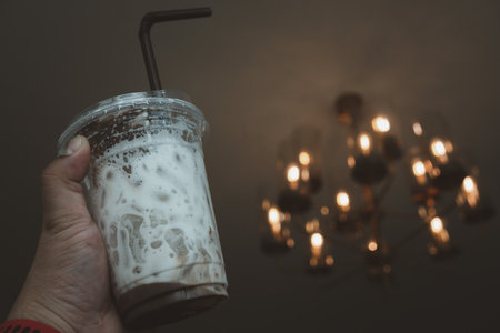 Hand holding a empty cool coffee glass after drink, show a texture of ice and milkの写真素材