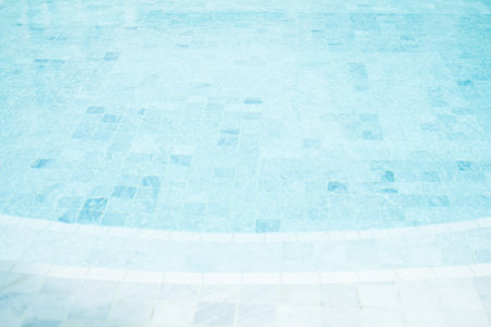 Clear blue water in the pool, curved swimming pool. Step into the water and finish the pool bottom slab mosaicの写真素材