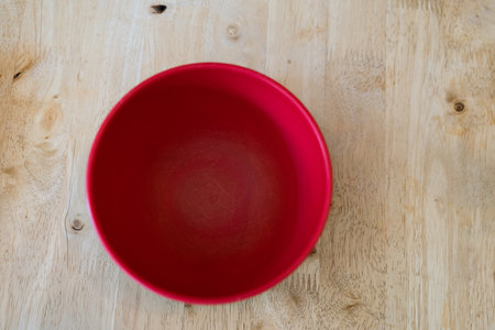 Empty plastic red bowl on wood backgroundの写真素材