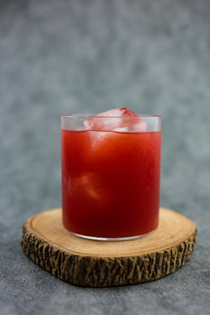 Fresh cold pressed watermelon juice with ice on a wooden coaster. Seasonal drinks. Close upの写真素材