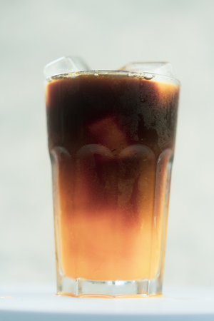 A glass of iced americano black coffee mixed with orange juice