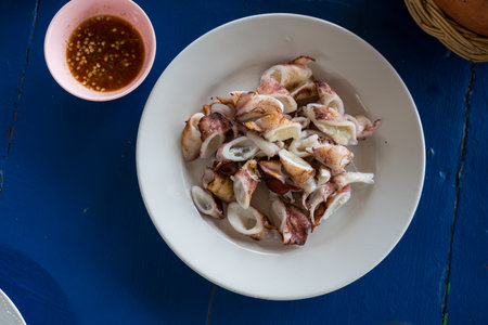 Grilled squid cut into pieces with seafood dipping sauce. Top viewの写真素材