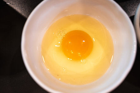 Fresh raw egg in a white bowl. Preparation of omeletの写真素材