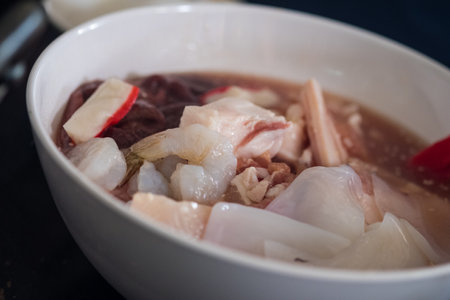 Thai style traditional cuisine is raw pork or seafood marinated for Thai style barbecue grill or Moo Krataの写真素材