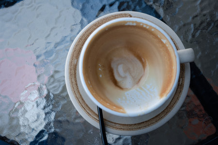 Empty cup dirty after coffee. Top view on a glass tableの写真素材