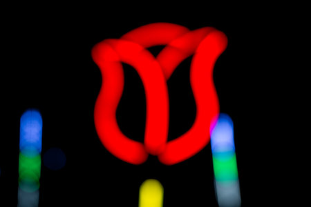 Blur background of neon tulips against a dark sky at night in festival temple fairの写真素材