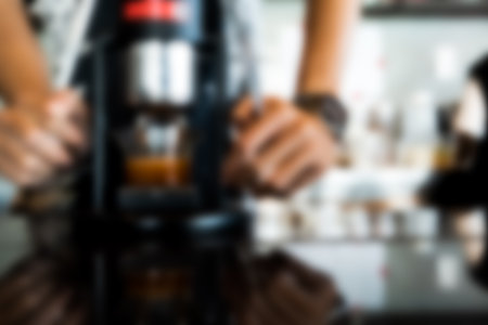 Blur background of a barista making hot espresso shot from coffee maker. Close upの写真素材