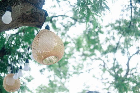 Bamboo woven lamp hanging on tree decoration in the garden. Beautiful weave bamboo lampの写真素材