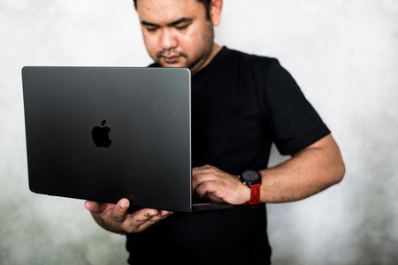 Bangkok, Thailand - December 16, 2023 : Man use and test Apple MacBook Pro M3 Max, Space Black, upgrade with speed, battery, and a dazzling new look. Apple launched a new MacBook Pro in 2023のeditorial素材
