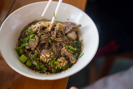 Thai beef clear soup white rice noodle vermicelli with braised beef. Delicious street fast food in Thailand. Selective focus.の写真素材