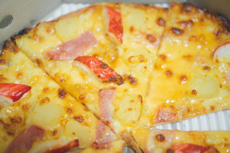 Pizza with ham and crab sticks placed on a paper box. Close up and selective focusの写真素材