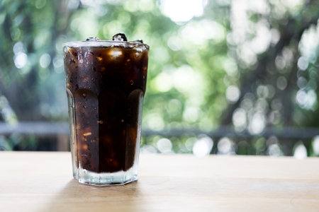 Close up glass of iced black coffee on wooden tableの写真素材