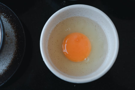 Raw fresh egg in white bowl for cooking or making shabu shabu and sukiyakiの写真素材