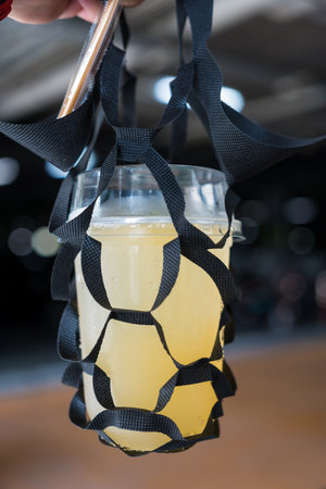 Man holding a glass of iced lemon mix honey with holding packaging for glass take away. Close upの写真素材