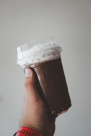 Iced mocha with milk or cream in hand. Close upの写真素材