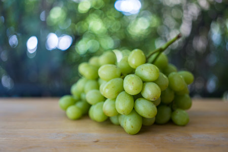 Bunch of ripe and juicy green grapes on wood tableの写真素材