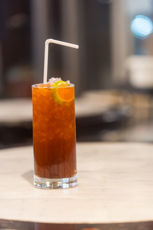 A glass of ice lemon tea with white straw. Close upの写真素材