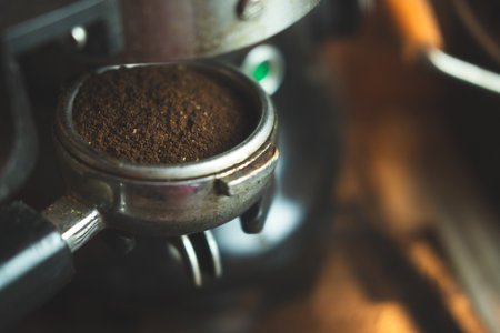 Close up ground arabica coffee from an electric grinder inside portafilter ready for brewing good espresso in cafeの写真素材