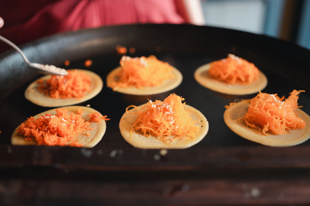 Vendor cooking and selling Thai traditional dessert, crispy pancakes in Thai style. Local culture and cuisine of Thailand.の写真素材