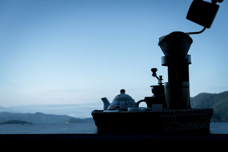 Man makes fresh coffee by dripping coffee or filter coffee against the blue sky and beautiful mountains in the morning in North Thailand, Nan provinceの写真素材